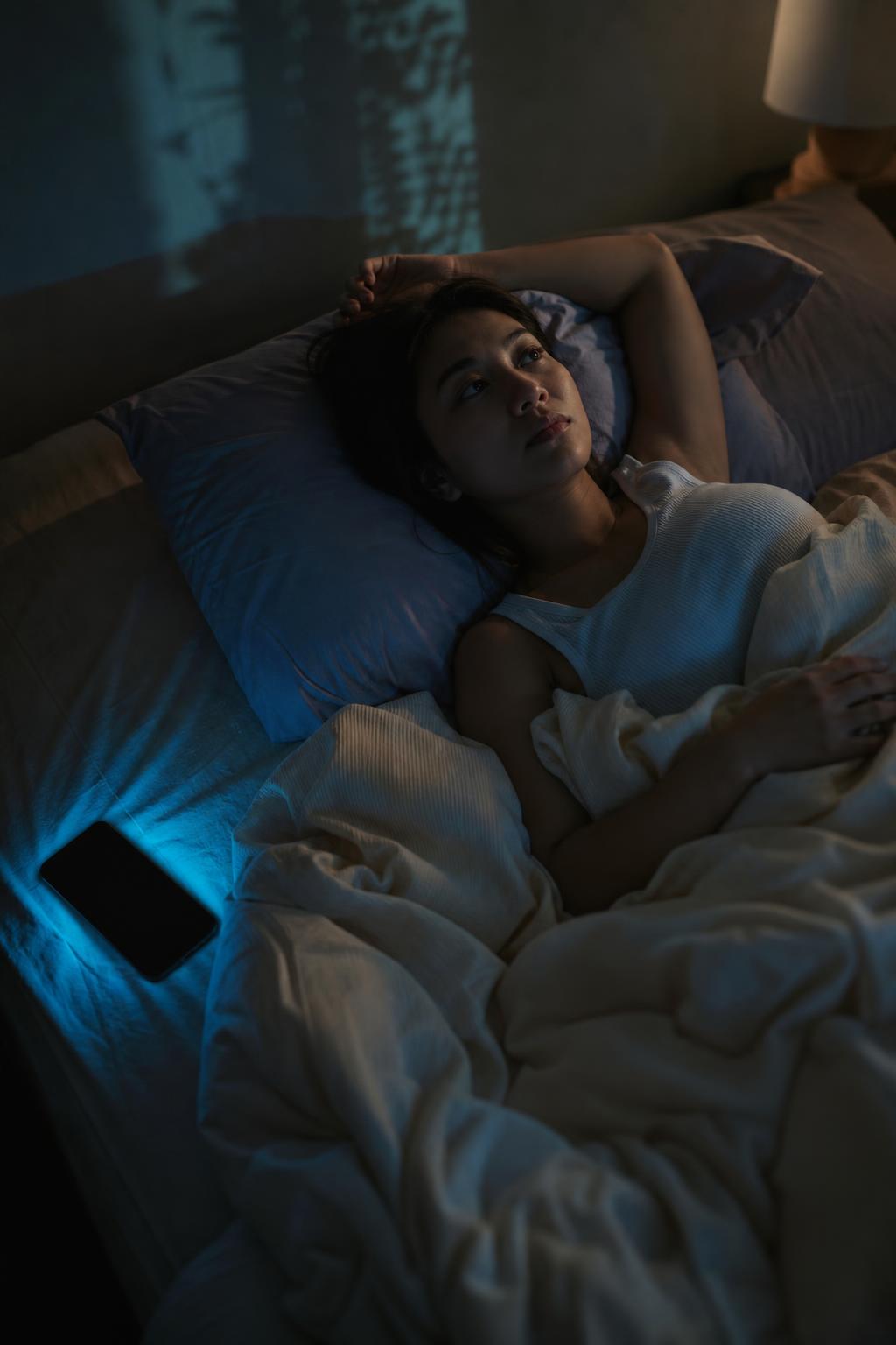 Person lying awake in bed at night